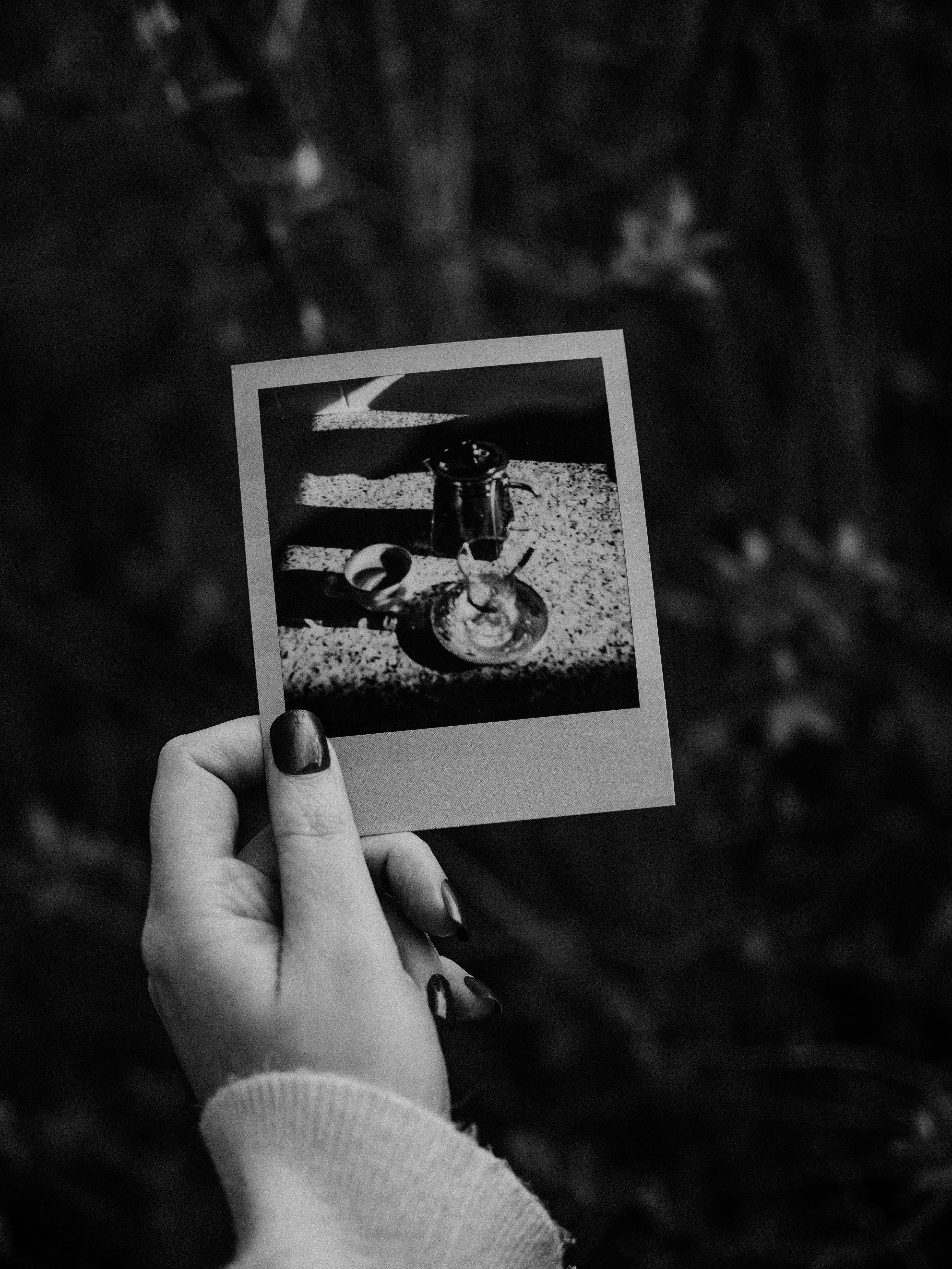 Mão feminina segurando uma foto Polaroid